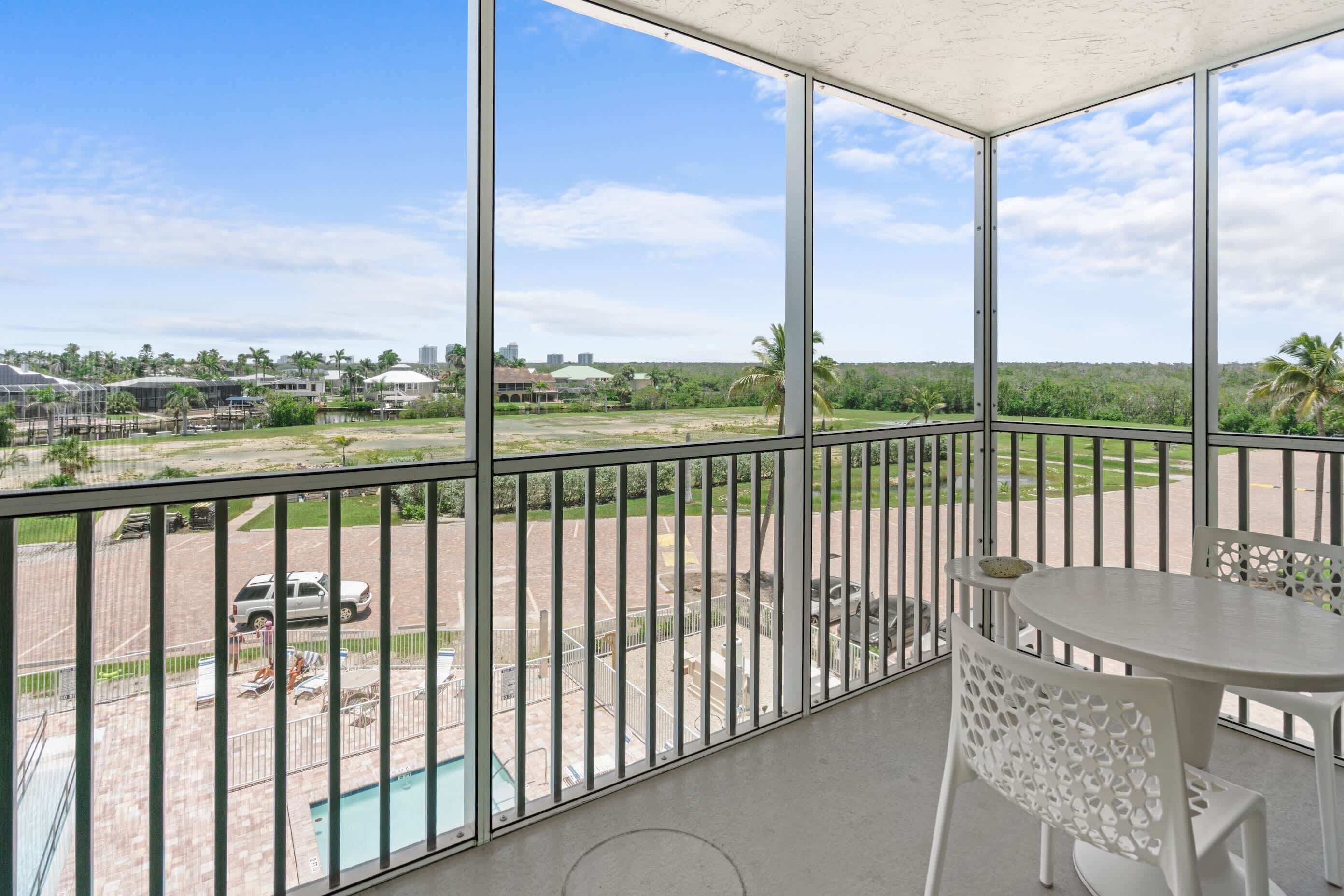 Un balcon donnant sur une piscine, avec une table et des chaises.