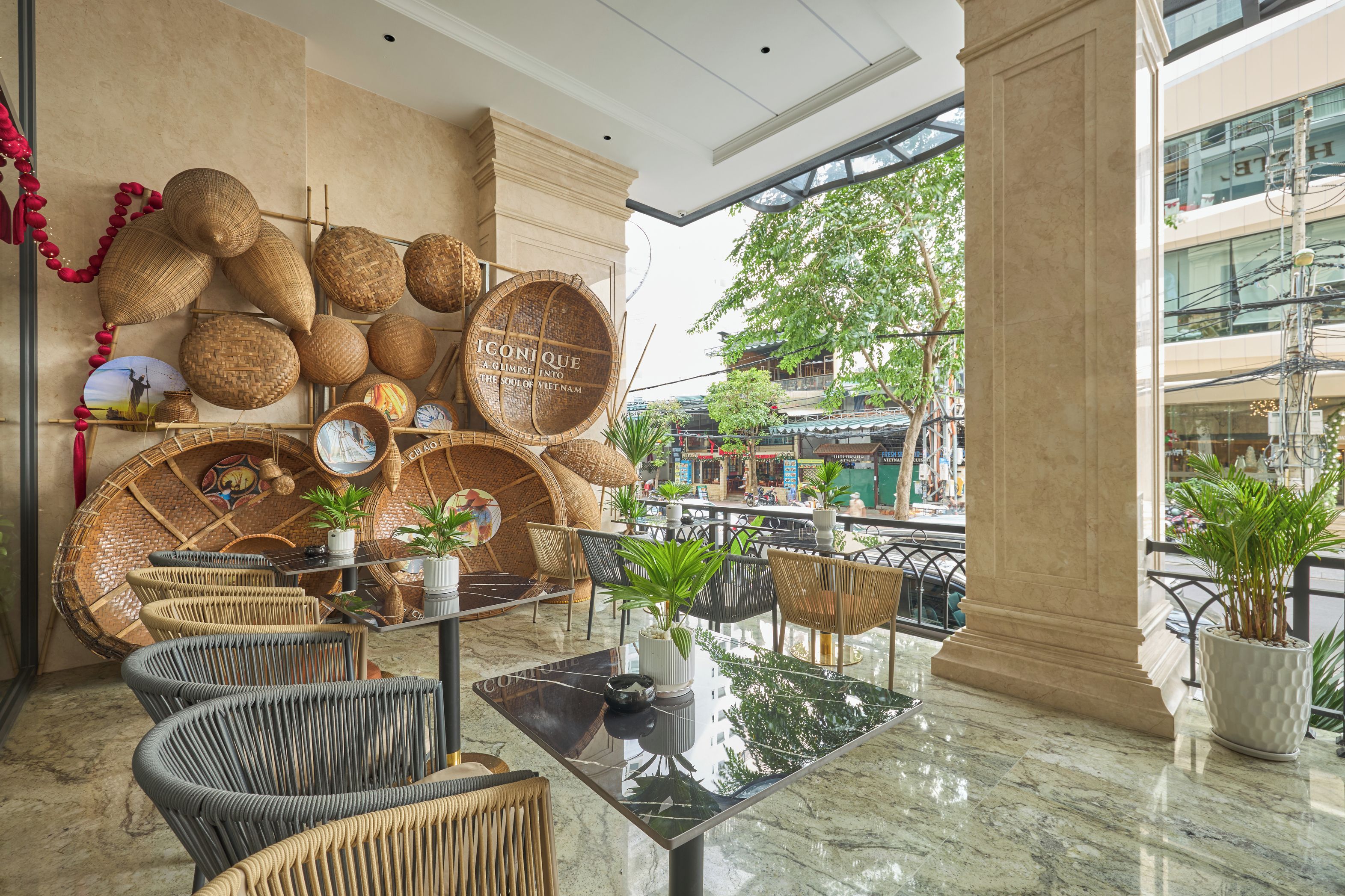 A modern interior with wicker furniture, a glass table, and a view of the street outside.