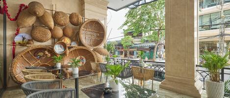 A modern interior with wicker furniture, a glass table, and a view of the street outside.