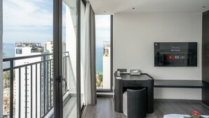 Un balcon moderne offrant une vue sur la mer et les bâtiments.