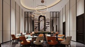 Una hall d'albergo moderna con un bar centrale, zona salotto e una parete decorativa con scaffali.