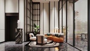 Un intérieur moderne avec un sol en marbre, un canapé d’angle, une table basse et une plante en pot.