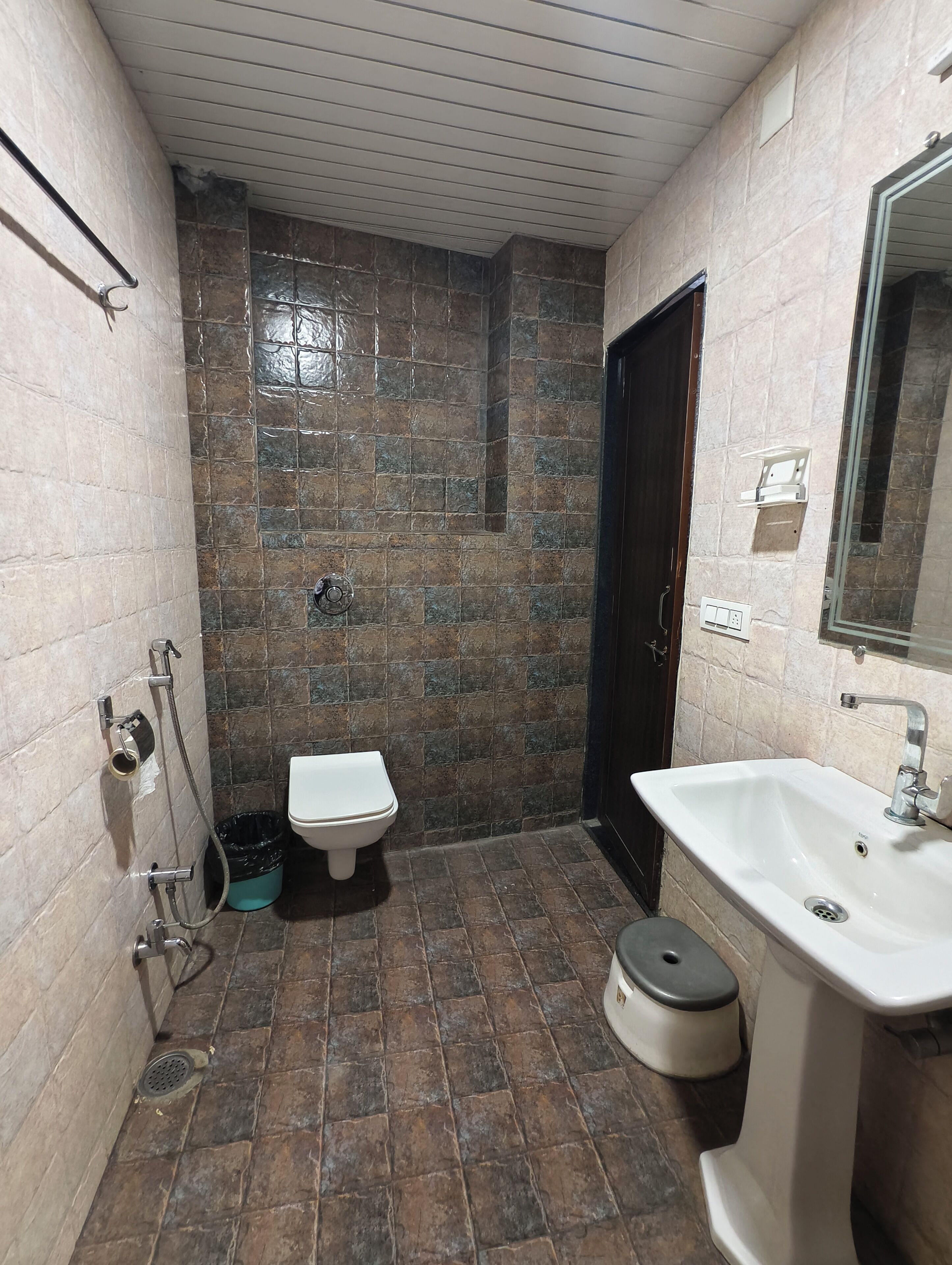A small bathroom with a toilet, sink, and shower.