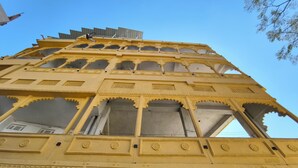 Un edificio de varios pisos con detalles arquitectónicos intrincados, incluyendo arcos y motivos decorativos.