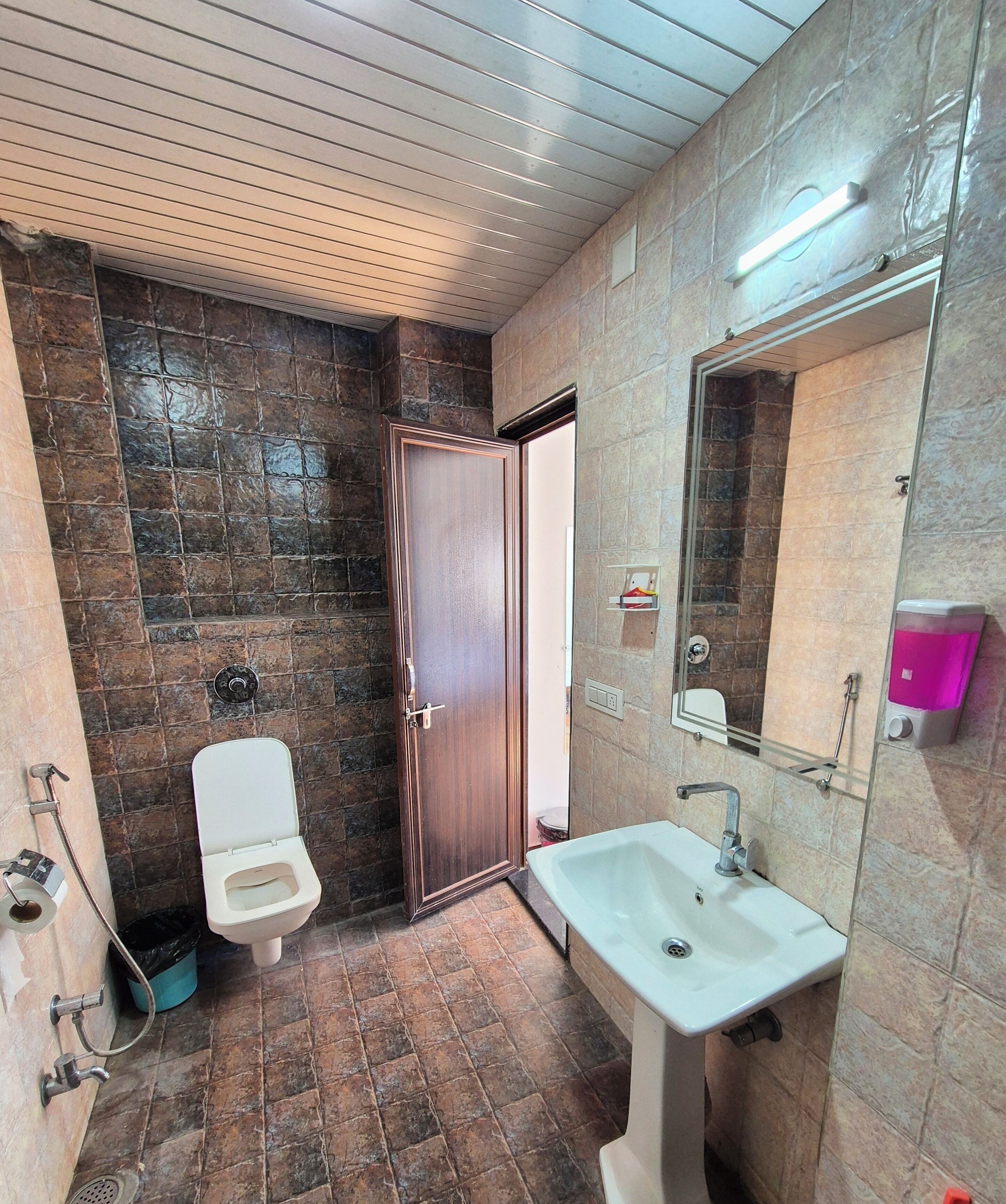 A bathroom with a toilet, sink, and shower area.