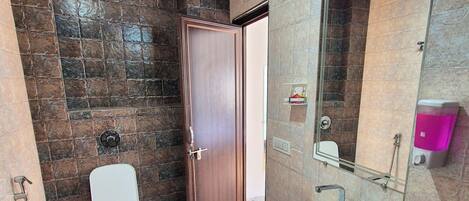 A bathroom with a toilet, sink, and shower area.