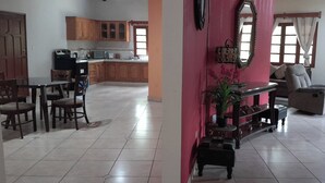 Amplia sala de estar con comedor, cocina y un gran ventanal.