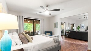 Un dormitorio amplio con una cama grande, un escritorio y vistas al exterior.