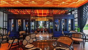 Un restaurante con una decoración moderna, que presenta mesas y sillas de madera, y un techo decorativo.