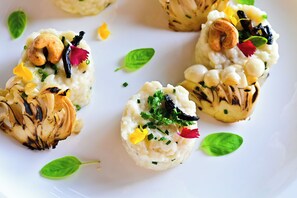 Un plato con comida, incluyendo verduras a la parrilla y guarniciones.