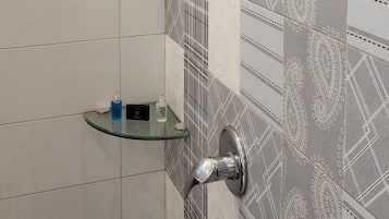 A shower with a handheld showerhead and a wall-mounted faucet.