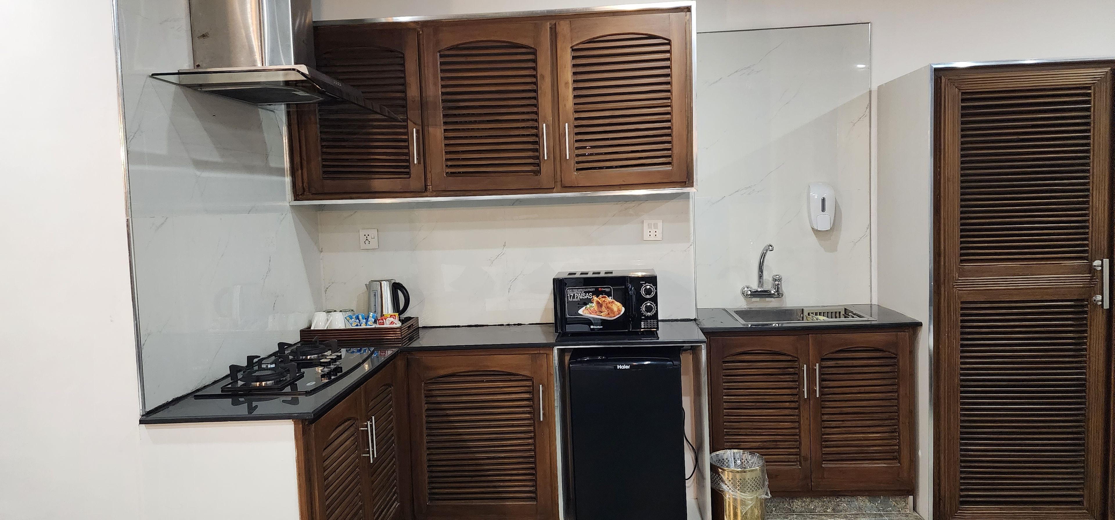 A kitchen with wooden cabinets, a gas stove, a black dishwasher, and a microwave.