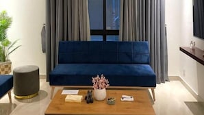 Una sala de estar moderna con un sofá azul, una mesa de centro de madera y una planta en maceta.