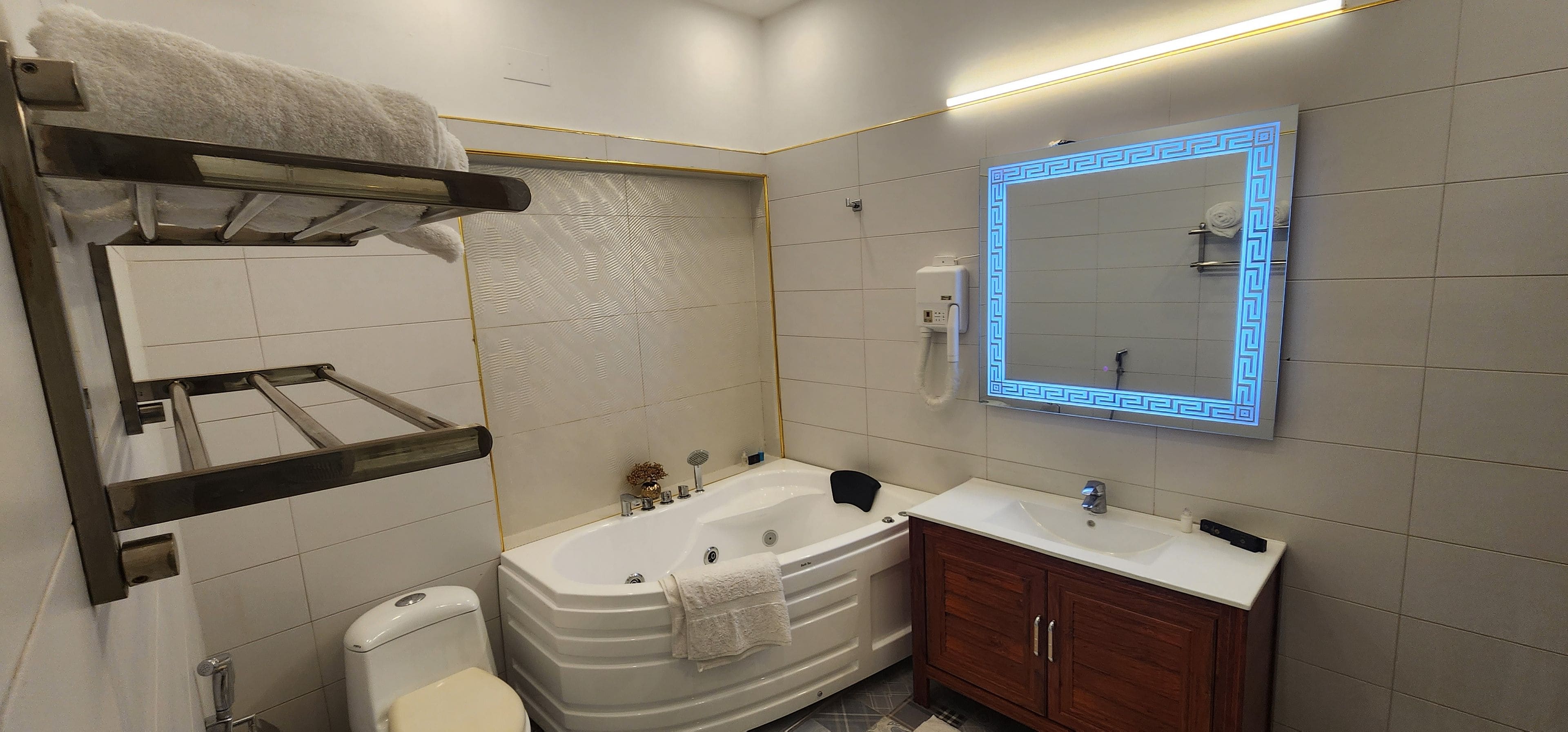 A modern bathroom with a bathtub, a toilet, a sink, and a vanity.
