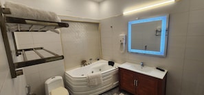 Casa de banho moderna com banheira, sanita, lavatório e toucador.