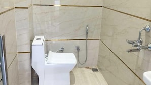 Une petite salle de bain moderne, équipée de toilettes, d’une douche et d’un lavabo.