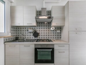 Réfrigérateur, un four, vaisselle et ustensiles