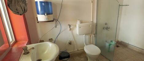 A bathroom with a white sink, toilet, and glass shower enclosure.