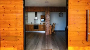 A wooden interior with a kitchen area featuring cabinets, a stove, and a clock on the wall. - Charming 2-bedroom villa with WiFi, AC in pleasant Vieux Grand Port (Vieux Grand Port)