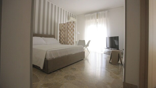 A bedroom with a bed, a TV, and a chair. - Relax in an apartment in the city center (Palermo)
