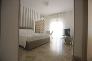 A bedroom with a bed, a TV, and a chair. - Relax in an apartment in the city center (Palermo)