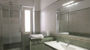 A modern bathroom with a glass-enclosed shower, a large sink, and a mirror. - Relax in an apartment in the city center (Palermo)