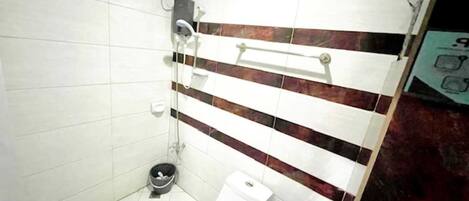 A small bathroom with a toilet, a shower, and a hand dryer.