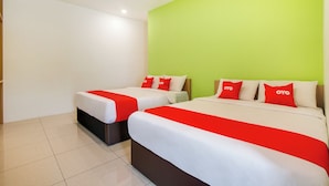 A hotel room with two beds, each with a red and white bedspread and matching pillows. The room has a green accent wall and white walls. - Cosmo Hotel (Quezon City)