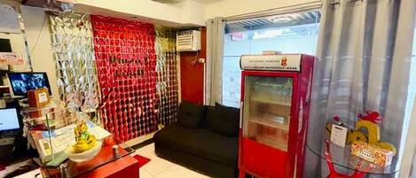 Un hall d’hôtel comprenant un comptoir d’accueil, un distributeur automatique et un espace salon.