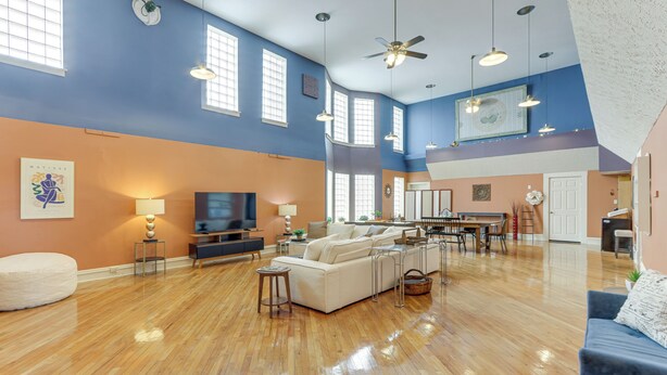 A spacious living room with a large sofa, a television, and a dining area with a table and chairs. - Downtown Apt: 23 Mi to Hocking Hills State Park (Lancaster)