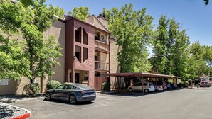 A multi-story building with a covered parking area. - Walk to Virginia Lake: Reno Condo w/ Balcony! (Reno)