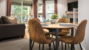 Un salon moderne avec un canapé, une table à manger et des chaises. On y trouve également un téléviseur et une cheminée.