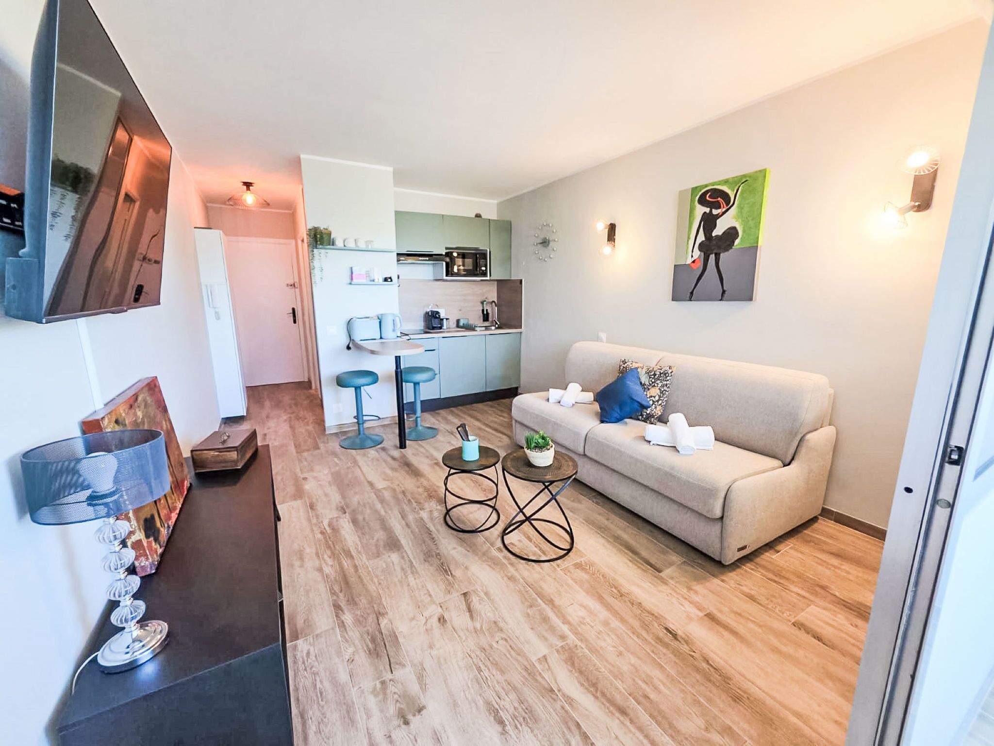 En moderne stue med sofa, sofabord og et køkken i baggrunden.