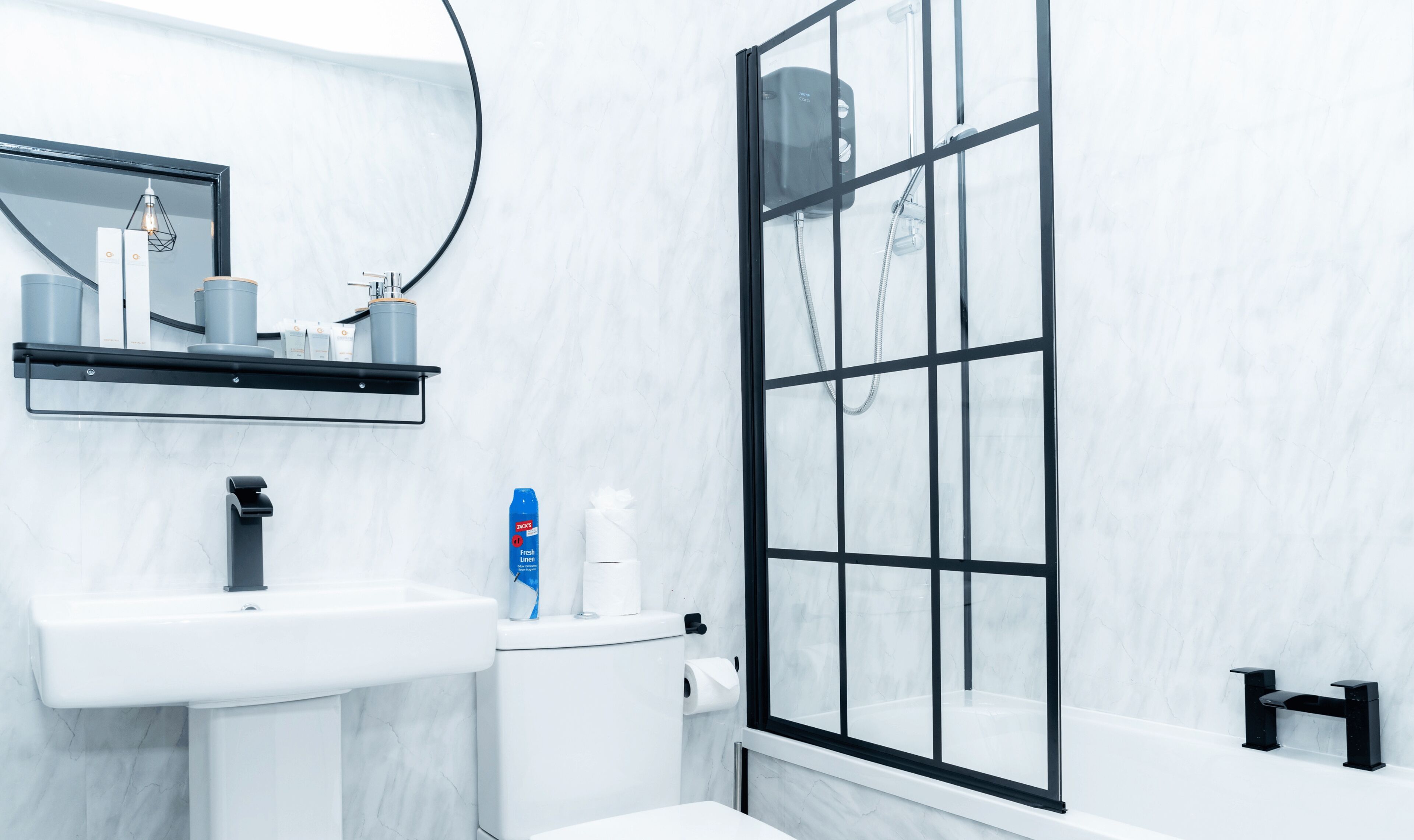 Ein modernes Badezimmer mit Waschbecken, Spiegel und Dusche.