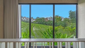 A view from a window with a balcony, overlooking terraced fields and residential buildings. - Exhale Villa by Betterplace (Canggu)