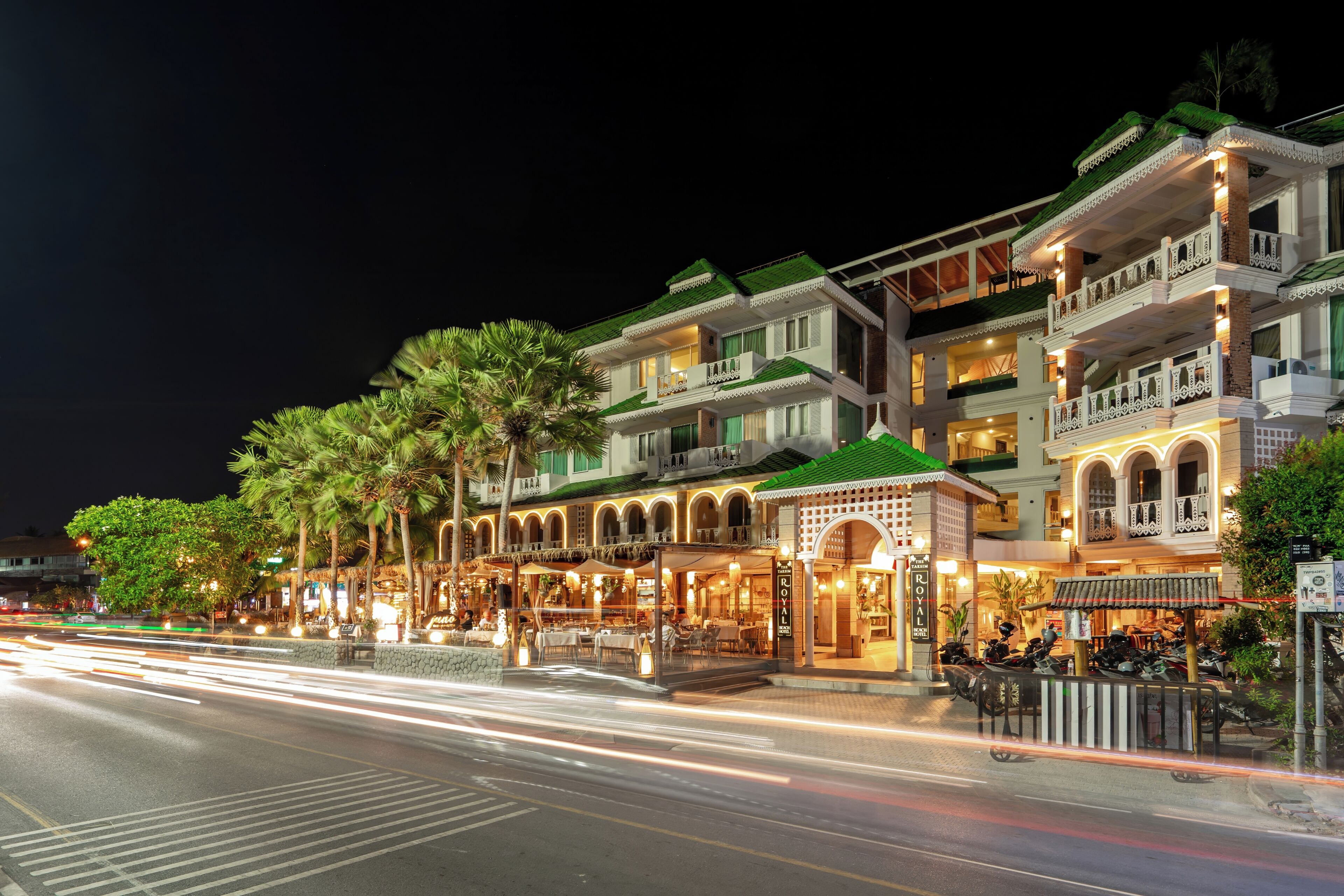 A multi-story hotel with balconies, a restaurant, and a sign that reads 'Royal.'