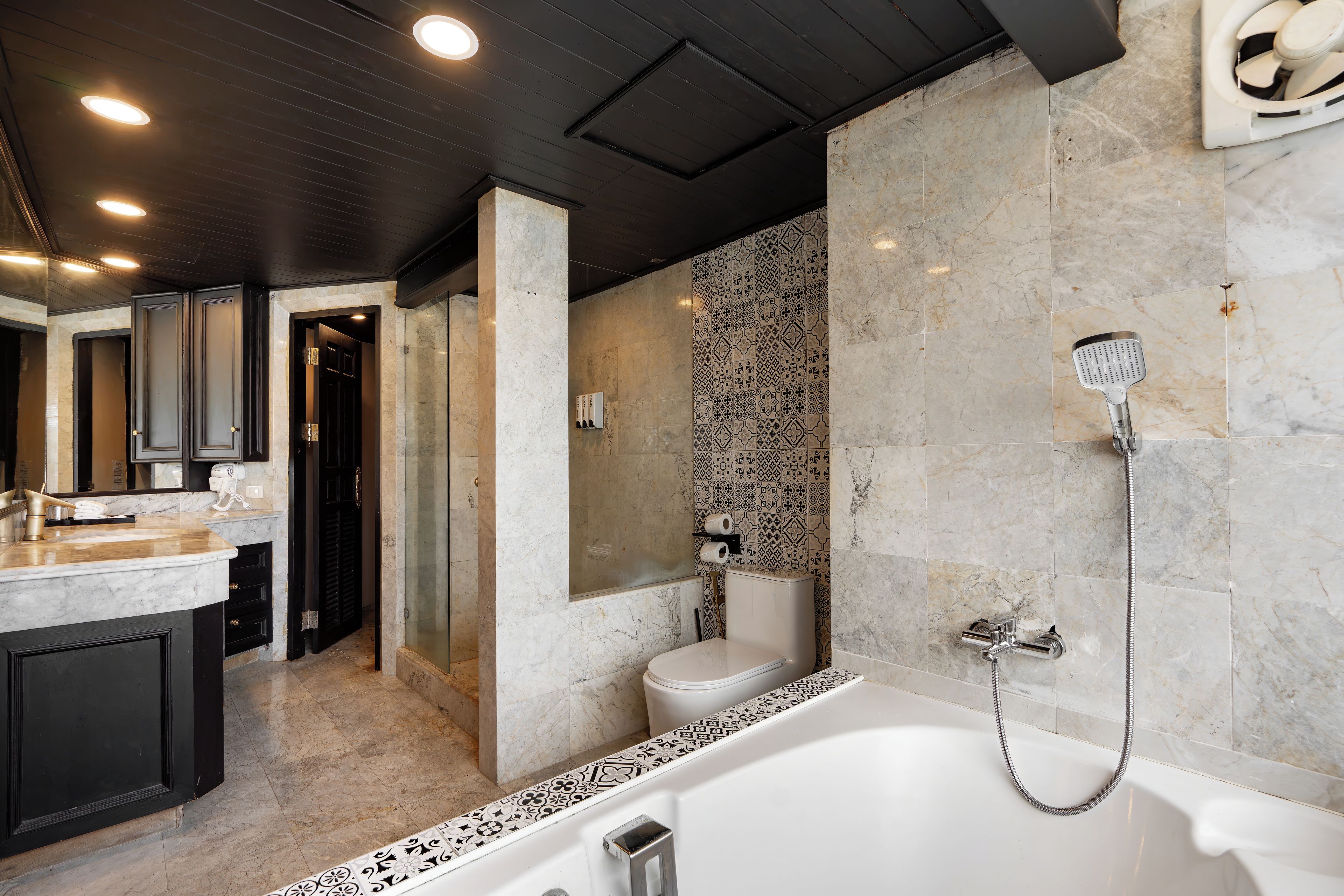 A modern bathroom with a bathtub, shower, and toilet.