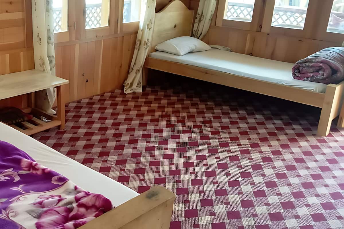 A wooden room with a bed, a bench, and a small table.