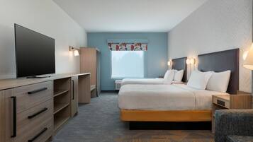 A hotel room with a bed, a TV, a desk, and a chair.