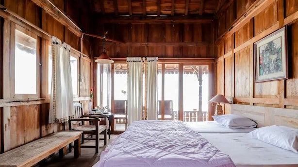 A wooden room with a bed, a desk, and a chair. - Villa Joglo Paris Yogyakarta (Parangtritis)