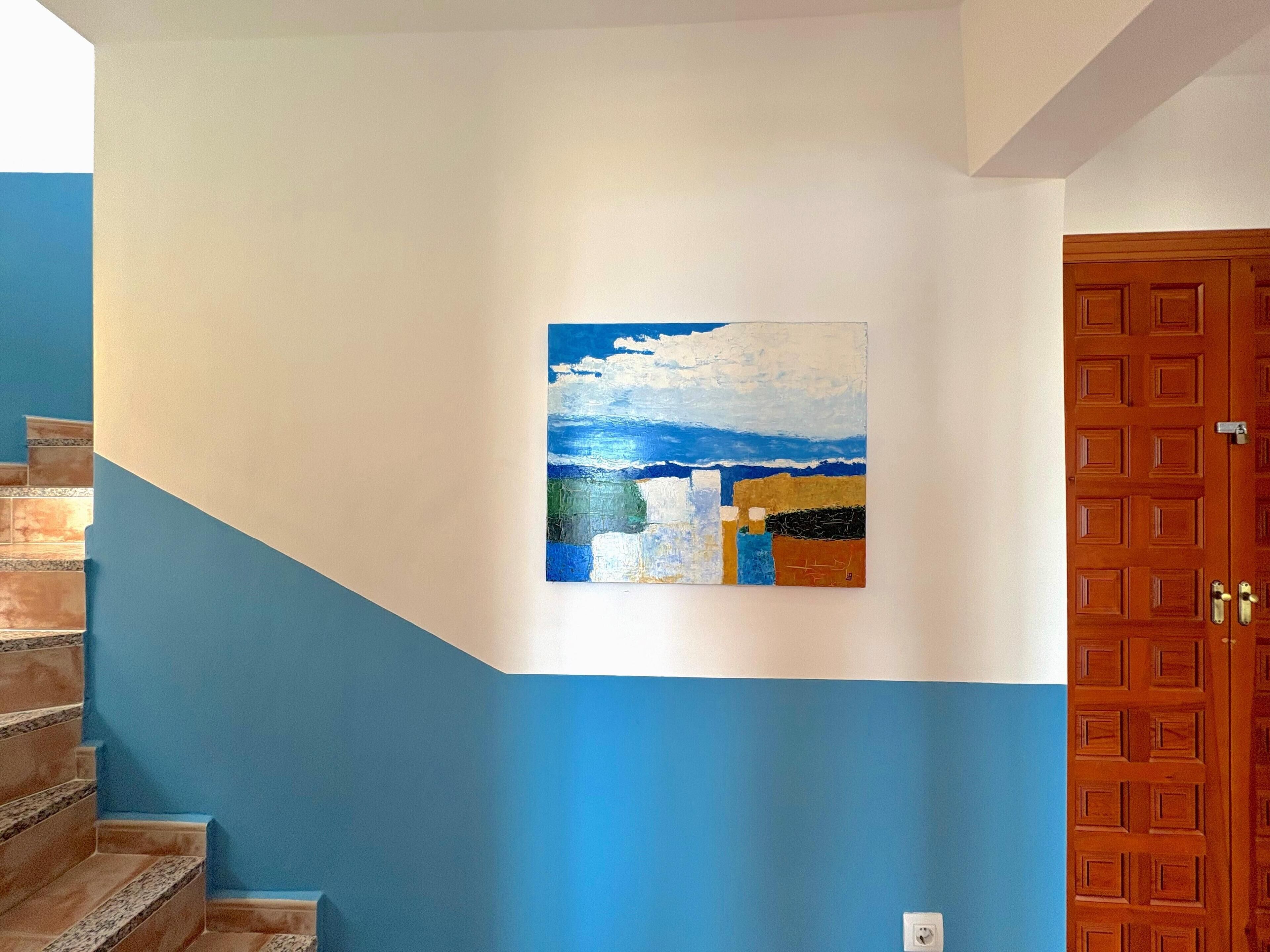 Eine Treppe mit blauen Wänden und einer Holztür.