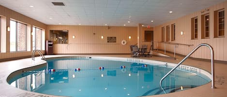 Ein Hallenbad mit Fliesenboden, einem Rettungsschwimmerstuhl und einem Schild, das das Tauchen verbietet.