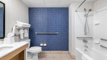 Een moderne badkamer met een blauw patroon op de muur, een wit toilet, een wastafel met spiegel en een douchehoek.