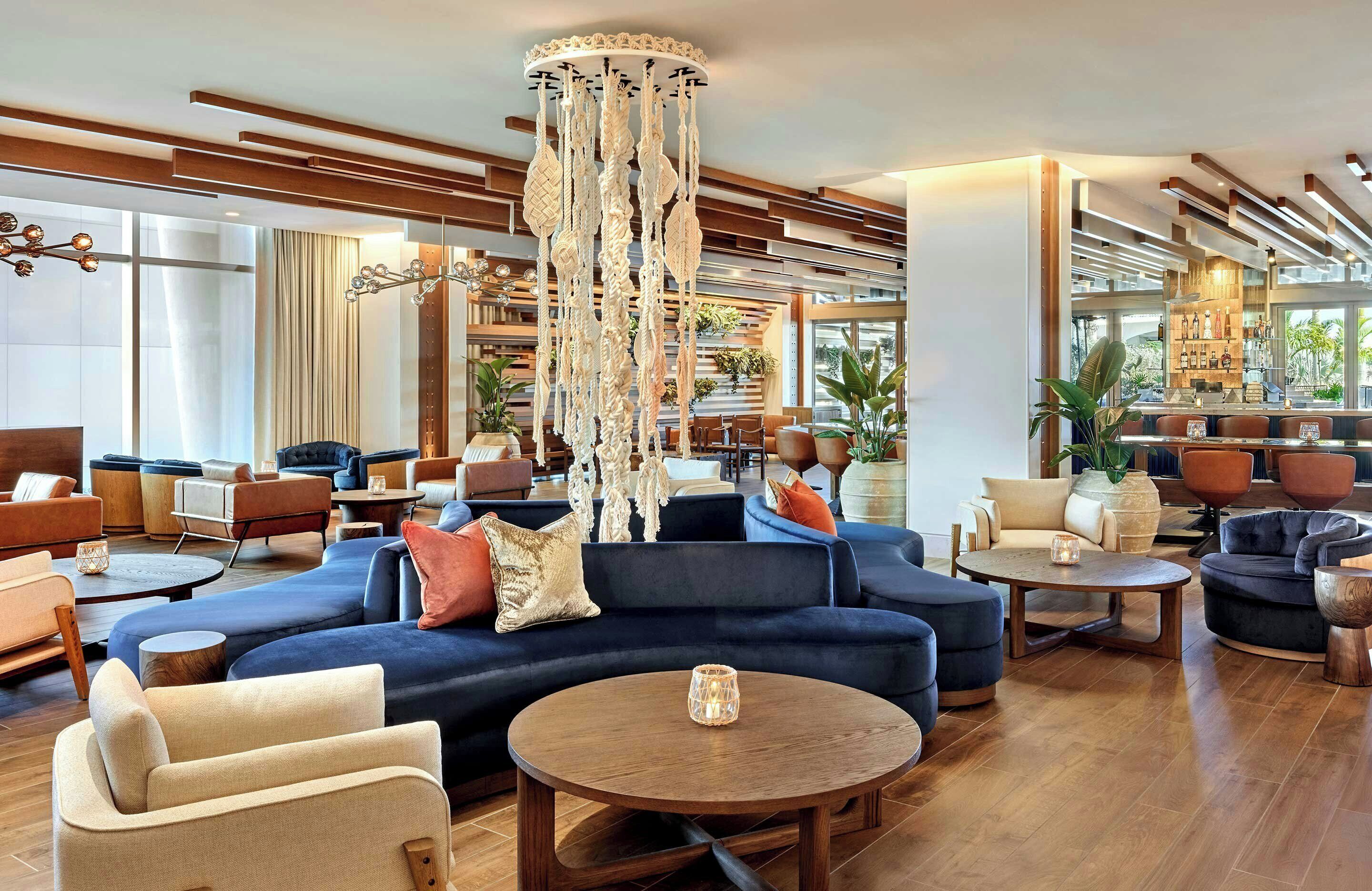 A modern lounge area with sofas, a coffee table, and a decorative hanging piece.