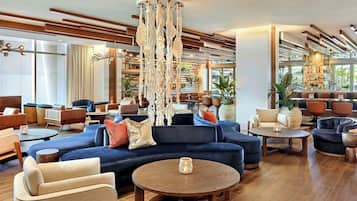 A modern lounge area with sofas, a coffee table, and a decorative hanging piece.