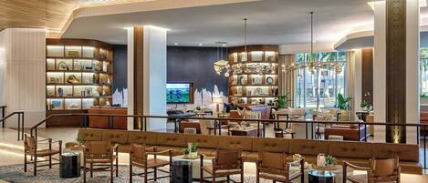 A spacious lobby with a central seating area, a television, and a large window with a view.