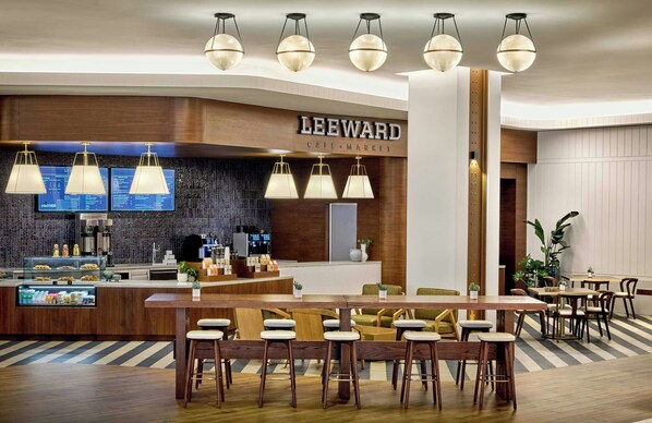 A cafe with a wooden counter, bar stools, and hanging pendant lights.