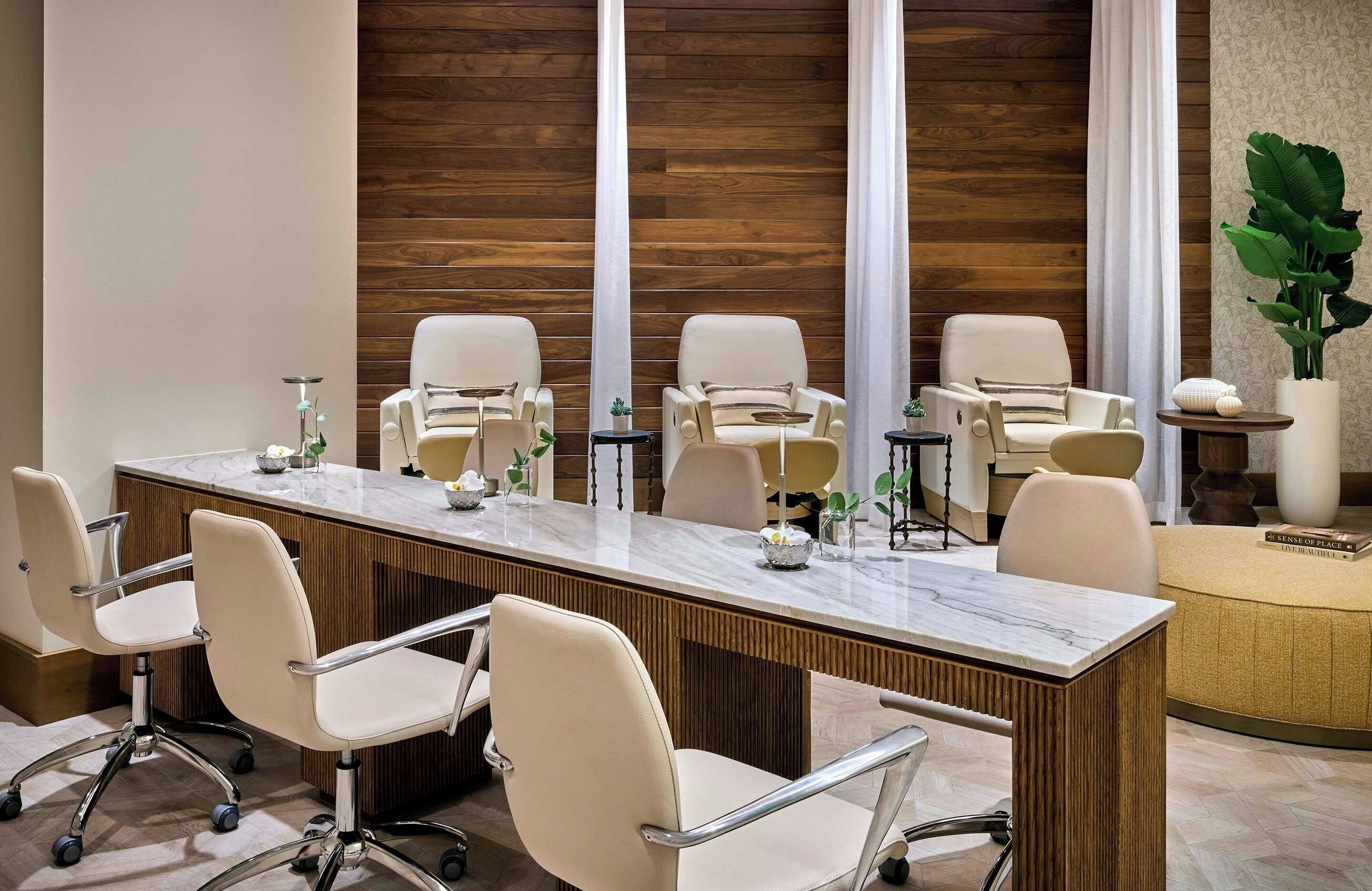 A conference room with a marble table, beige chairs, and a wooden wall.