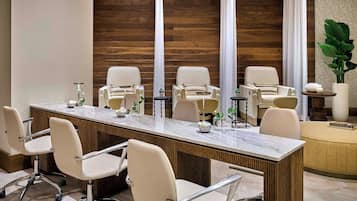 A conference room with a marble table, beige chairs, and a wooden wall.