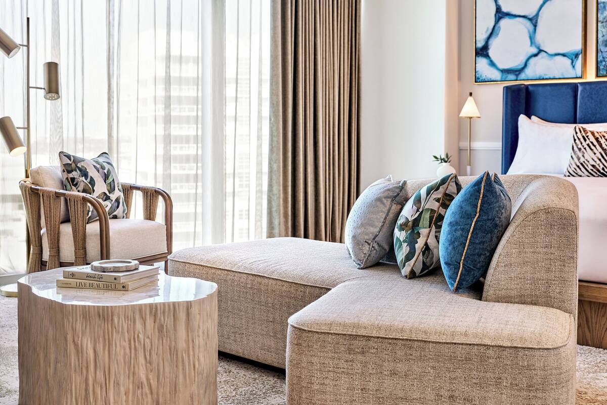 Un salon moderne avec un canapé, un fauteuil et une table basse ronde.